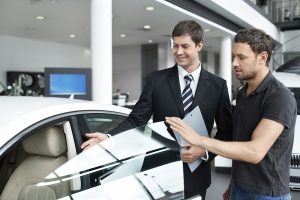 Young man with a salesman in a motor show