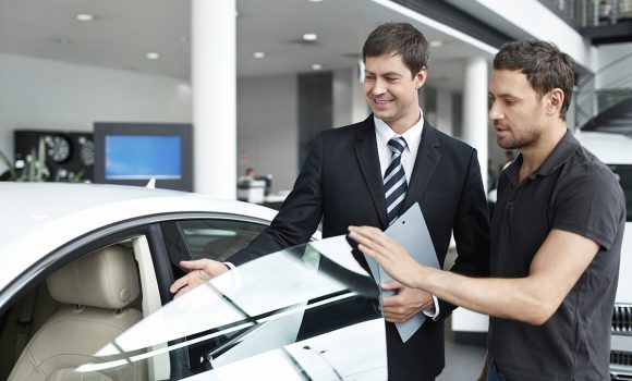 Young man with a salesman in a motor show