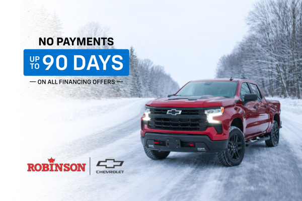 Red Chevrolet Silverado 1500 LT Trail Boss driving on a snowy Huron County road during a January Chevrolet promotion.