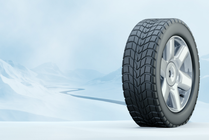 A winter tire standing upright on a snowy field