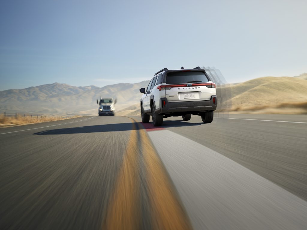 2026 Subaru Outback driving on a highway with EyeSight lane keep assist and sway warning helping the vehicle stay in its lane.