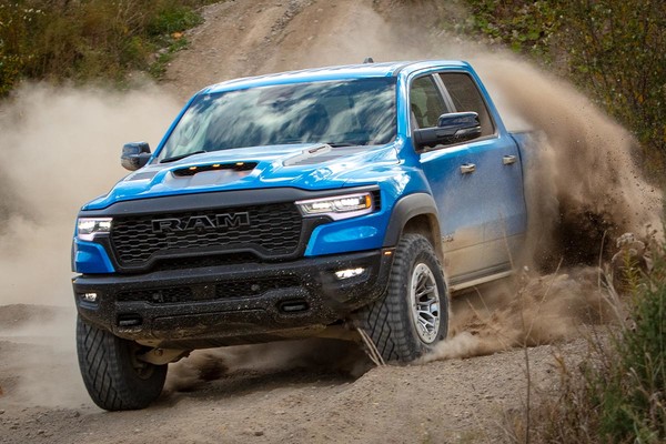 A blue 2026 Ram RHO kicks up dirt clouds on the off-road