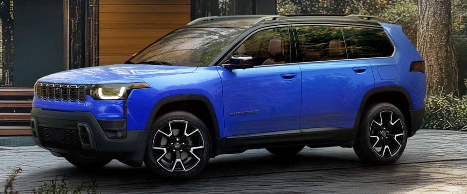 A blue 2026 Jeep Cherokee parked outside of a cabin