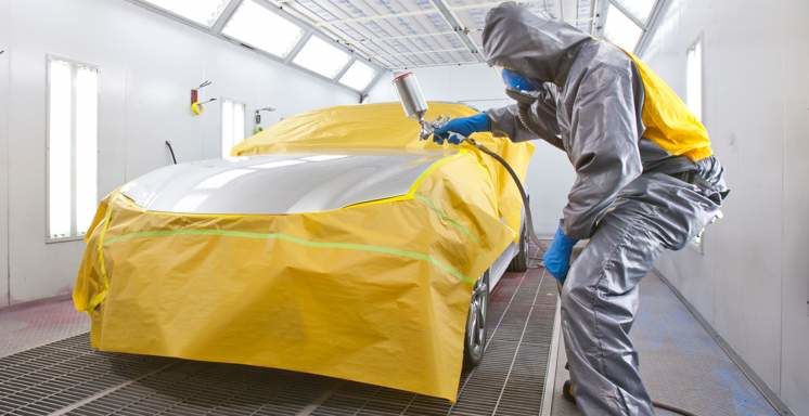 A Lexus-certified technician at Tony Graham Lexus in Ottawa inspects a paints in the collision paint bay, ensuring precision and quality craftsmanship during every repair.