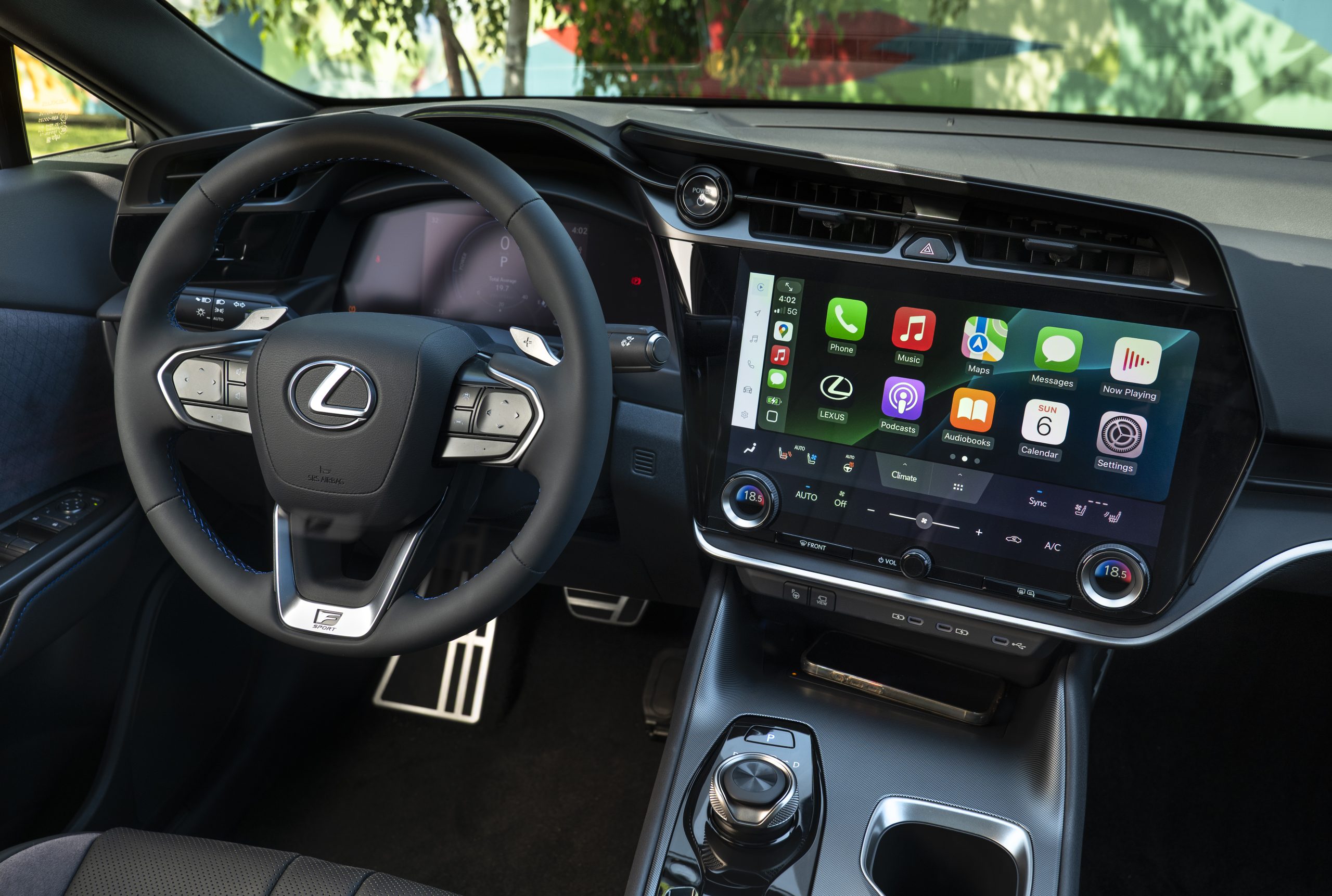 Interior of the 2026 Lexus RZ 550e F SPORT AWD showcasing steering wheel, 14-inch Lexus Interface touchscreen, and Apple CarPlay display.