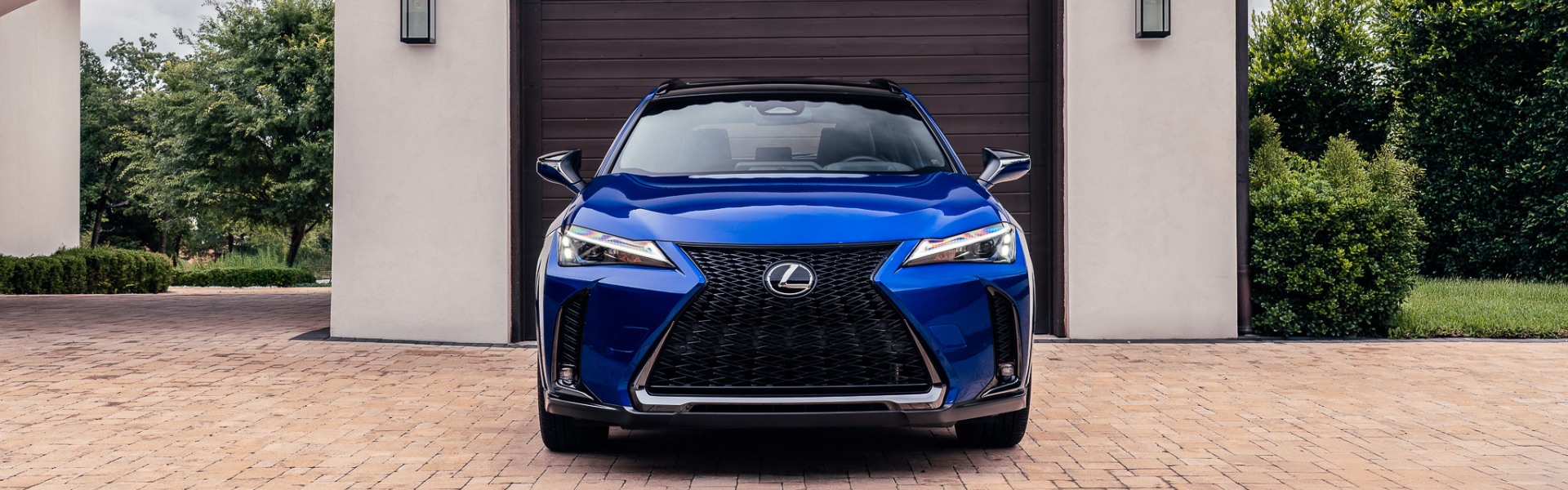 Front exterior view of a blue Lexus UX showing the spindle grille and LED headlights