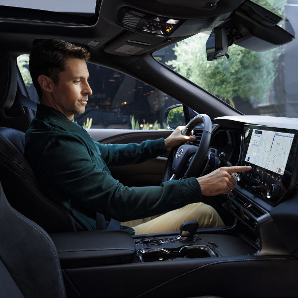 Driver using the touchscreen display inside the 2026 Lexus RX Plug-In Hybrid at Tony Graham Lexus in Ottawa