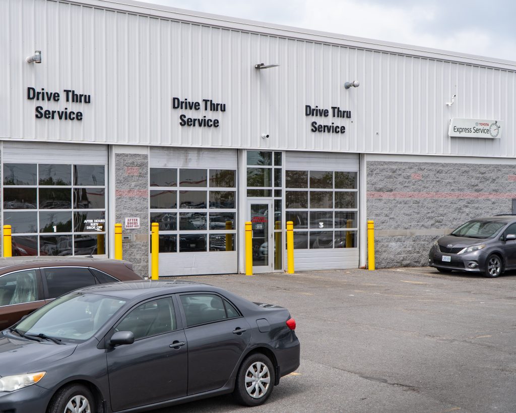 Toyota technician inspecting vehicle under the hood at Tony Graham Toyota service centre in Ottawa