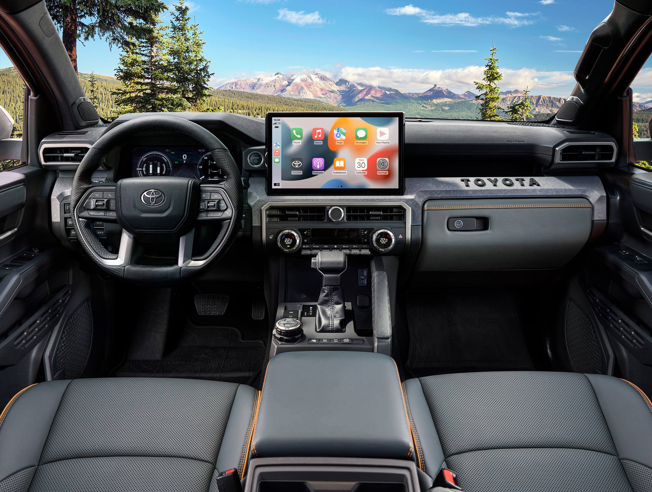 Interior view of a Toyota Tacoma showing the dashboard, steering wheel, center console, and touchscreen display
