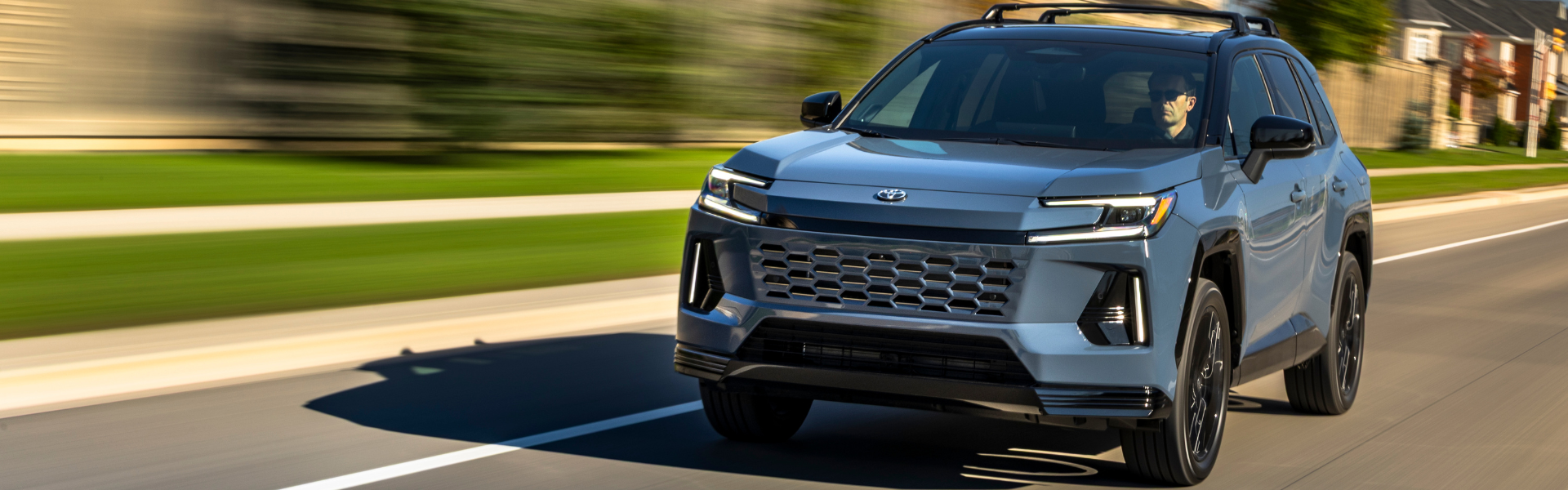 Toyota RAV4 driving on a paved road in a suburban area