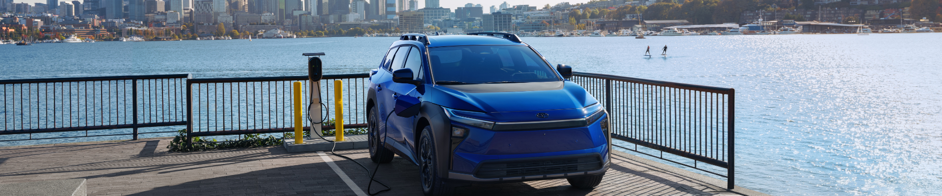 2026 Toyota bZ Woodland front three-quarter view parked by a waterfront city skyline