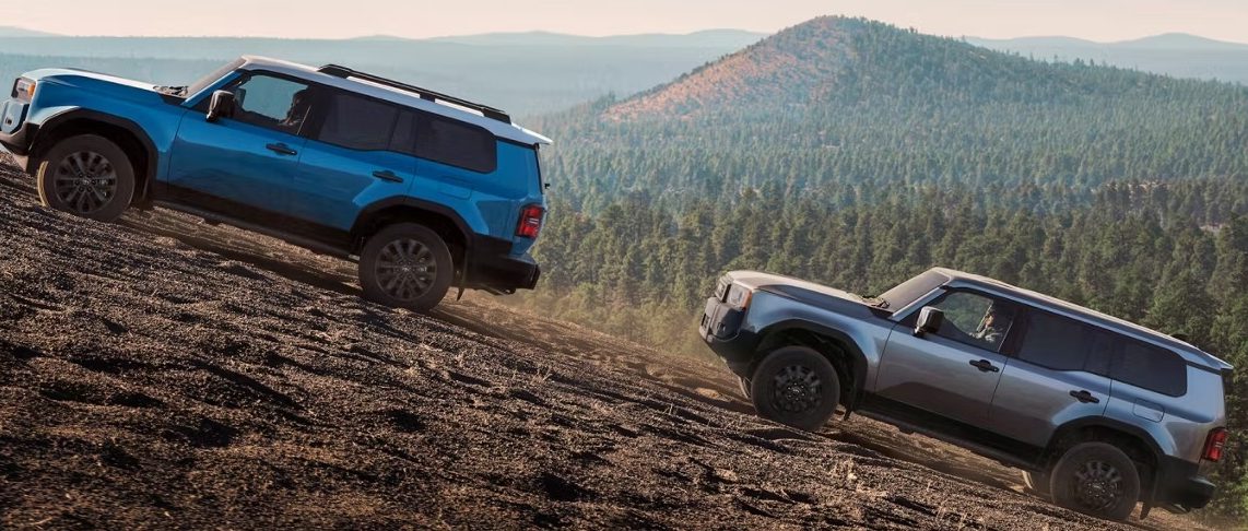 2025 land cruiser moving uphill alongside land cruiser 1958.