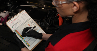 Technician making note on clipboard.