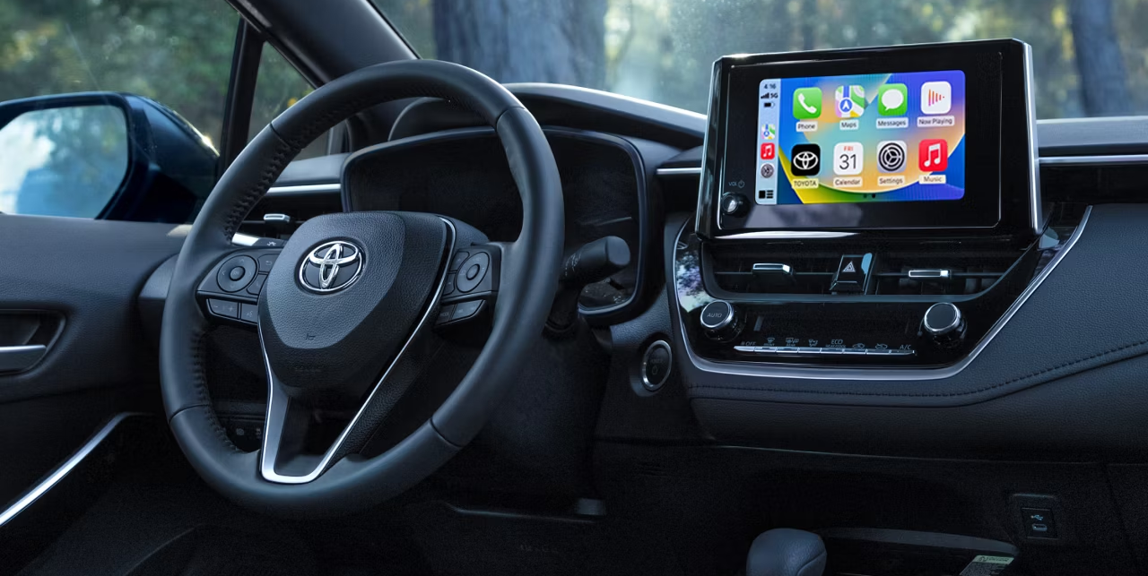 Screen and steering wheel inside Toyota vehicle.