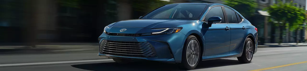 2025 Toyota Camry driving on road during daytime.