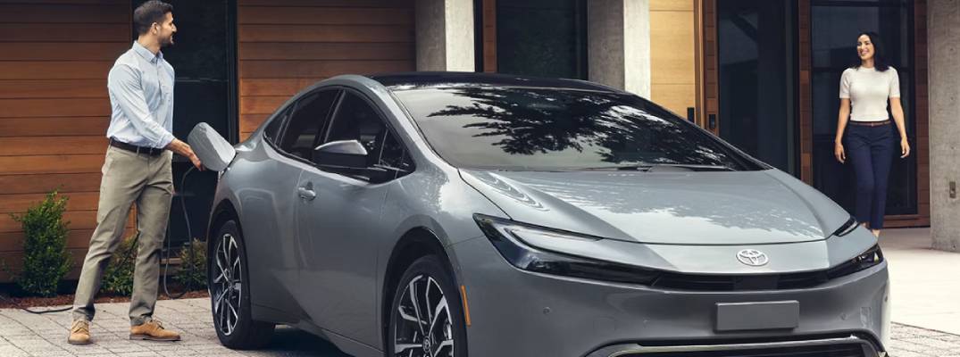 People standing near 2026 Prius PHEV parked outdoors