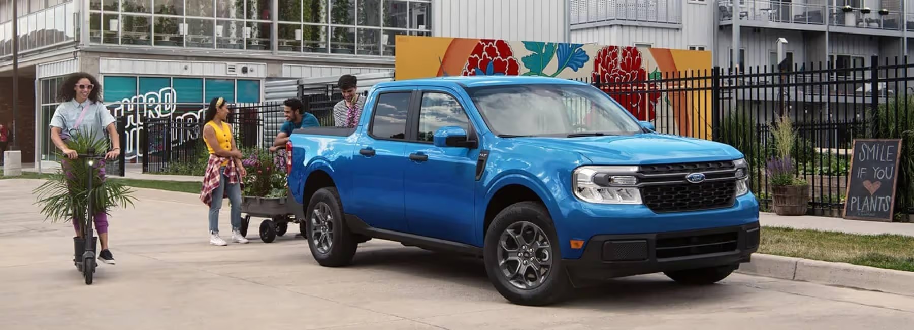 imgi_31_Person-riding-a-scooter-past-people-loading-plants_