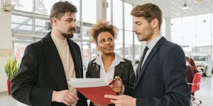 A couple discusses buying a used vehicle from a dealership salesman.