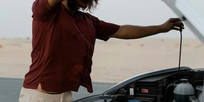 A vehicle owner looks under the hood of his used car.