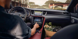 Driver using console in 2025 INFINITI QX55. Interior shot in the daytime.