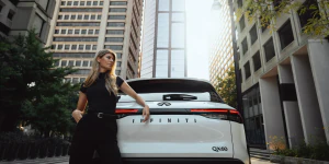 Unknown person standing behind 2025 INFINITI QX60 parked on street