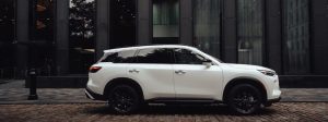 Side view of : 2025 INFINITI QX60 parked on city street.