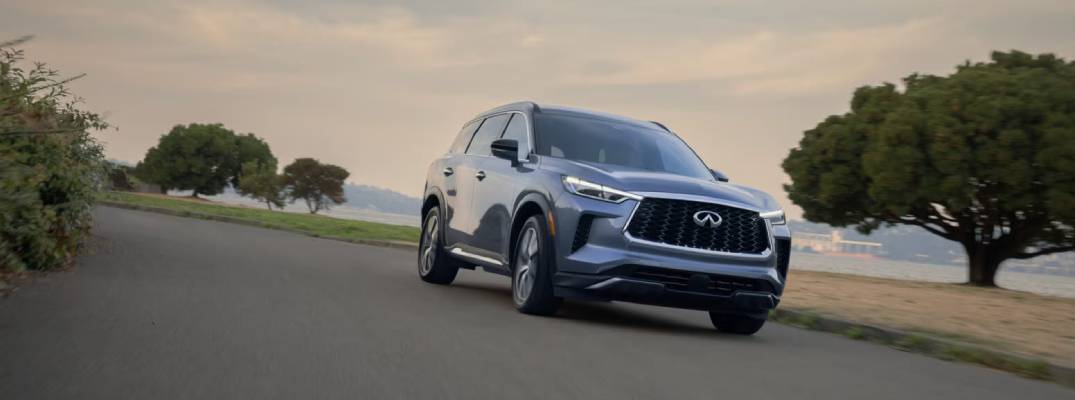 2025 INFINITI QX60 driving down road 
