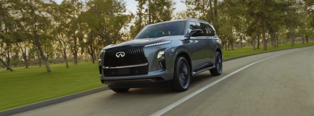 2026 infiniti qx80 driving down road in daylight