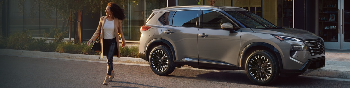 Woman walking in front of 2026 Nissan Rogue