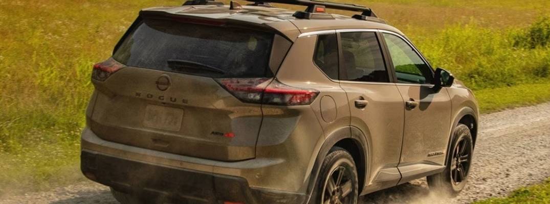 2026 Nissan Rogue covered in dirt driving down pathway