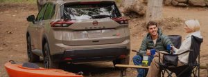 Unknown people sitting in chairs behind 2026 Nissan Rogue Rock Creek.
