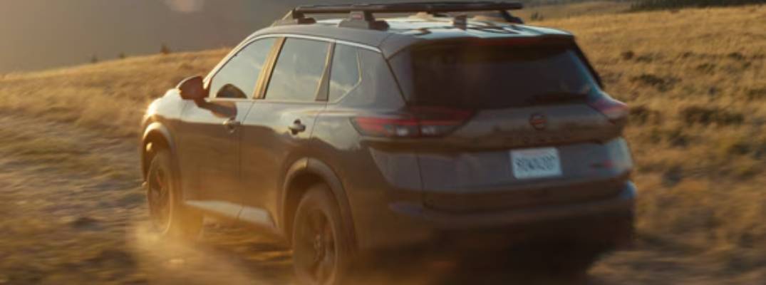 2026 Nissan Rogue driving through dirt terrain. 