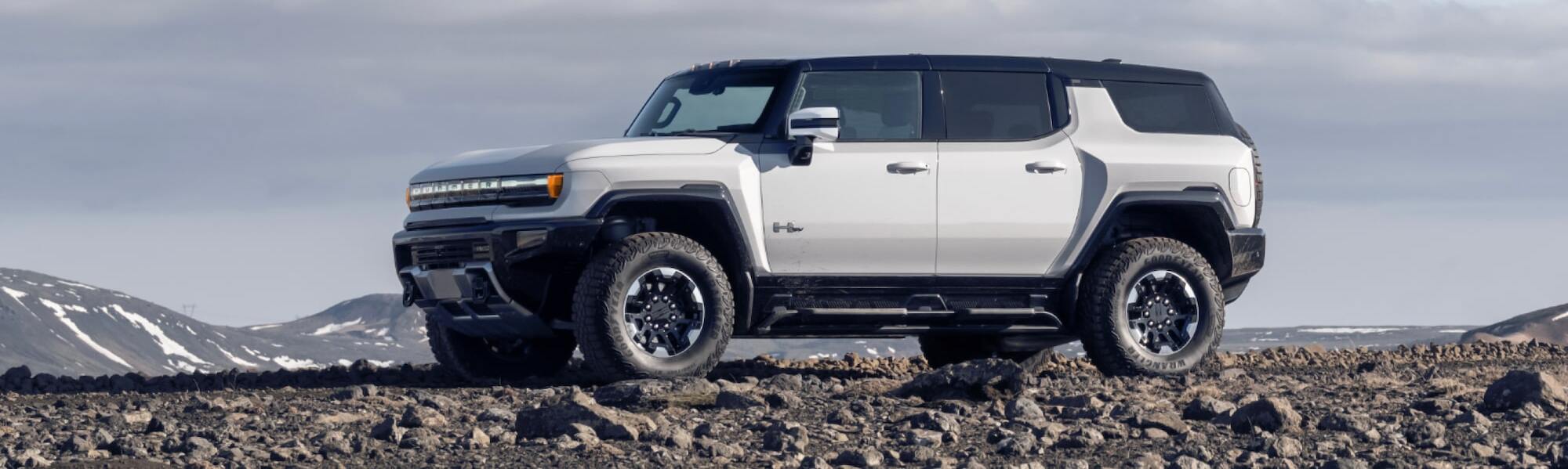 2025 GMC Hummer EV SUV parked on rocky terrain.