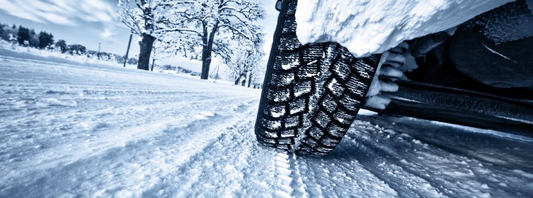 Vehicle driving through snow closeup on tire