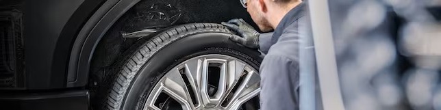 Unknown person examining car wheel