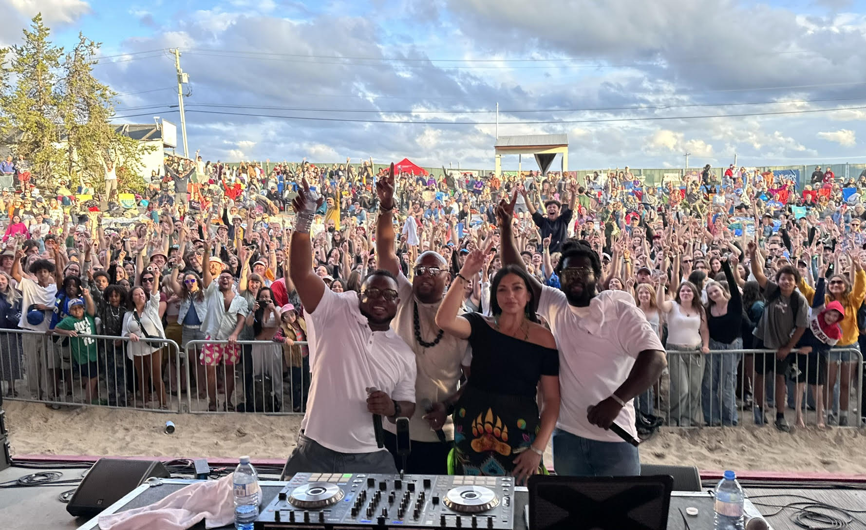 Aaron “Godson” Hernandez on stage with unknown people, large crowd of people behind him.